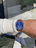 MONTAUK CHRONO men's watch on wrist — blue chronograph dial with red-brown leather strap, outdoor lifestyle photo